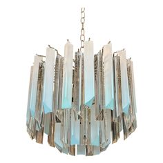 an art deco chandelier with blue glass panels and metal chains hanging from the ceiling