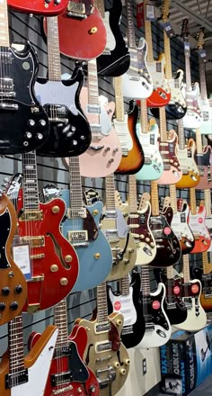 many guitars are hanging up on the wall in this store, and there is no image here to provide a caption for