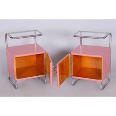 two pink and chrome side tables with open doors on each side, one is turned over