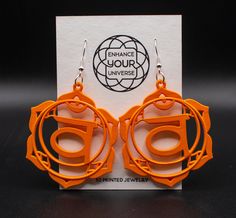 an orange pair of earrings sitting on top of a card