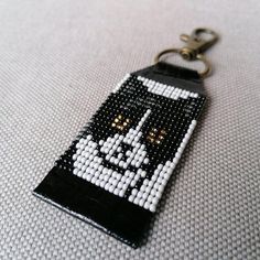 a keychain made out of beads with an image of a cat on it