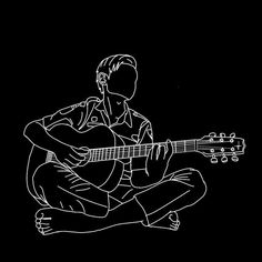 a person sitting on the ground playing a guitar