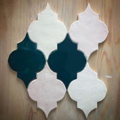 four different colored tiles on a wooden surface