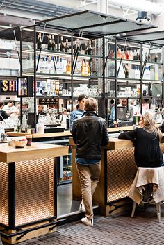 two people sitting at a bar in a restaurant