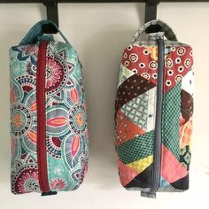 two bags are hanging on the wall next to each other, one has a zippered closure