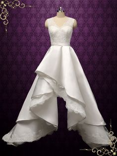 a white wedding dress on display in front of a purple background