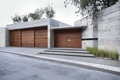 two garage doors are open on the side of a building with steps leading up to them