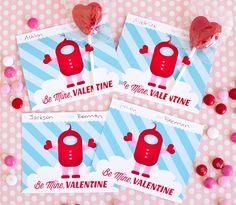 three valentine's day candy lollipops on a pink and blue background