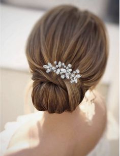 a woman wearing a bridal hair comb with crystal stones on it's side