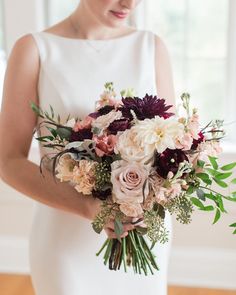 a woman holding a bouquet of flowers in her hands