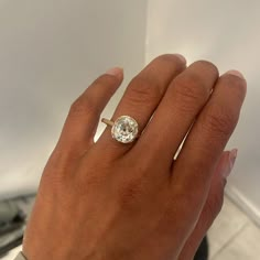 a woman's hand with a diamond ring on it