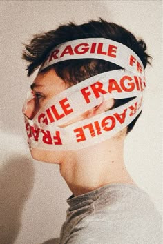 a young man with tape around his face has the words fragile and fragile on it