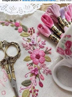 a pair of scissors sitting on top of a table next to some thread and spools