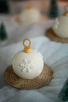 two small white balls with snowflakes on them sitting on top of a table