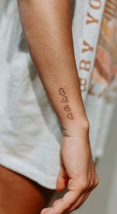 a person with a small tattoo on their left arm and the word love is written in cursive font