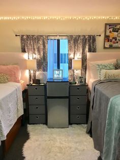 two beds in a room with lights on the ceiling and curtains hanging from the windows