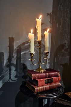 three candles are lit on top of books