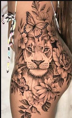 a woman's thigh with a lion and flowers on it