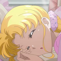 a blonde haired woman laying on top of a bed next to a window with her eyes closed