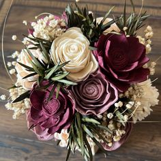 a bouquet of flowers sitting on top of a wooden table