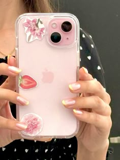 a woman holding up her phone case with stickers on it