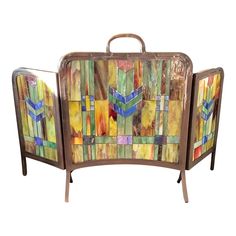 an art piece is shown with colorful tiles on the back and sides, as well as metal handles