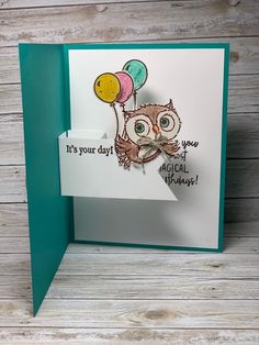 an owl with balloons on it's head is holding a card that says, it's your day