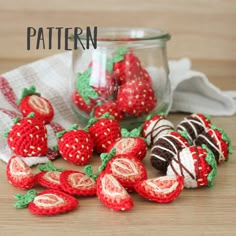 crocheted strawberries and chocolate covered strawberries in a glass jar on a table