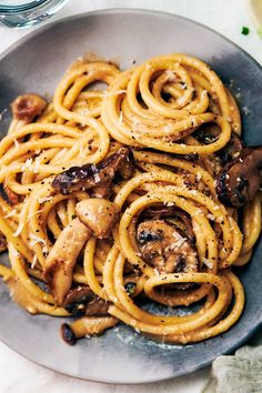 a plate full of pasta with mushrooms and sauce