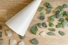 some sea glass and a paper cone on a table