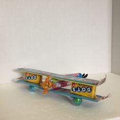 a toy snowboard sitting on top of a white shelf with gummy bears in it