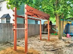 an outdoor play area with swings, climbing frame and swing set in the back yard