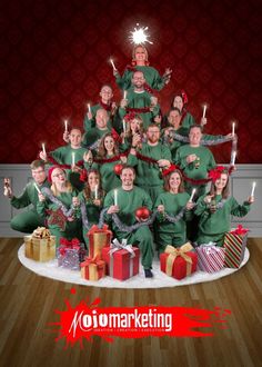 a group of people in green shirts are posing for a photo with presents and candles