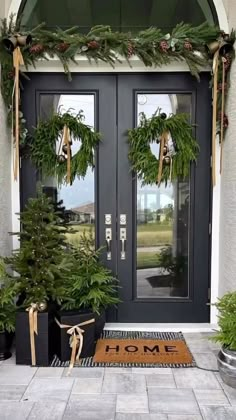 the front door is decorated with christmas wreaths