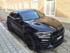 a black bmw x6 parked on the street