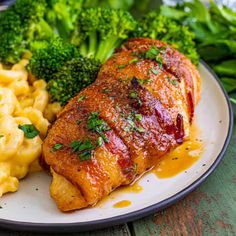 a plate with meat, macaroni and cheese and broccoli on it