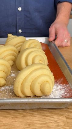 a person is cutting some food on a table with a knife and cookie sheet in front of them