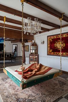 a bedroom with a bed and chandelier hanging from it's ceiling beams