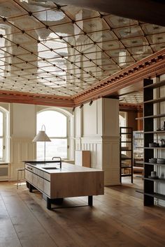 an empty room with wooden floors and lots of windows on the ceiling, along with shelves