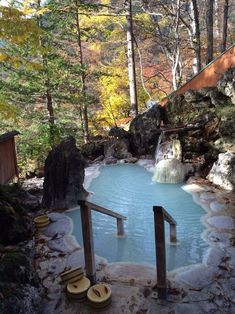 an outdoor hot tub surrounded by trees and rocks