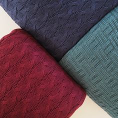 four different colors of knitted sweaters on top of each other