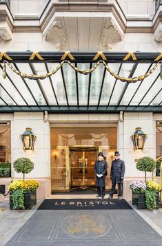 two men standing in front of a hotel entrance