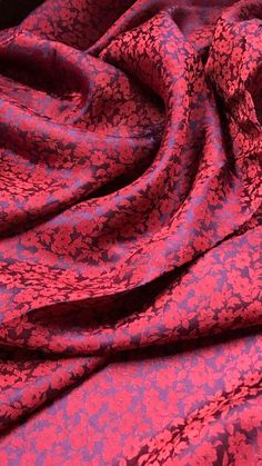 a pink and purple fabric with small flowers on the bottom, as well as an intricate design