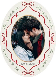 a couple kissing in front of a christmas ornament