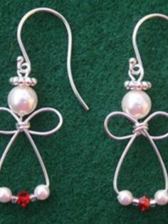 two pairs of earrings with bows and pearls on them, sitting on a green surface