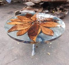 a glass table with wooden leaves on it