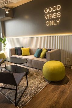 a living room filled with furniture next to a wall mounted sign that says good vibes only