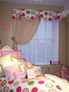 a child's bedroom decorated in pink, green and yellow with polka dot curtains