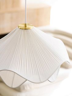 a white lamp hanging from a ceiling in a room