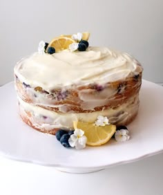 a cake with lemons and blueberries is on a plate